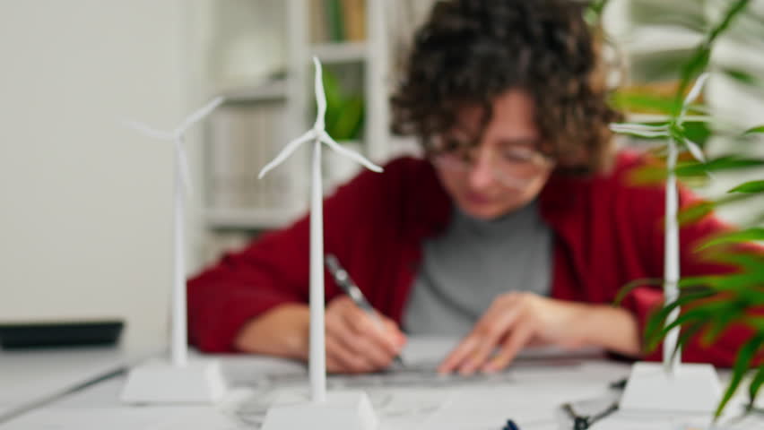 Generator, Girl worker Attentively sits at the planning desk 3d model of a wind turbine mini mockup In slow motion Young woman manages affairs in the office, Renewable resource
 Royalty-Free Stock Footage #1099939055