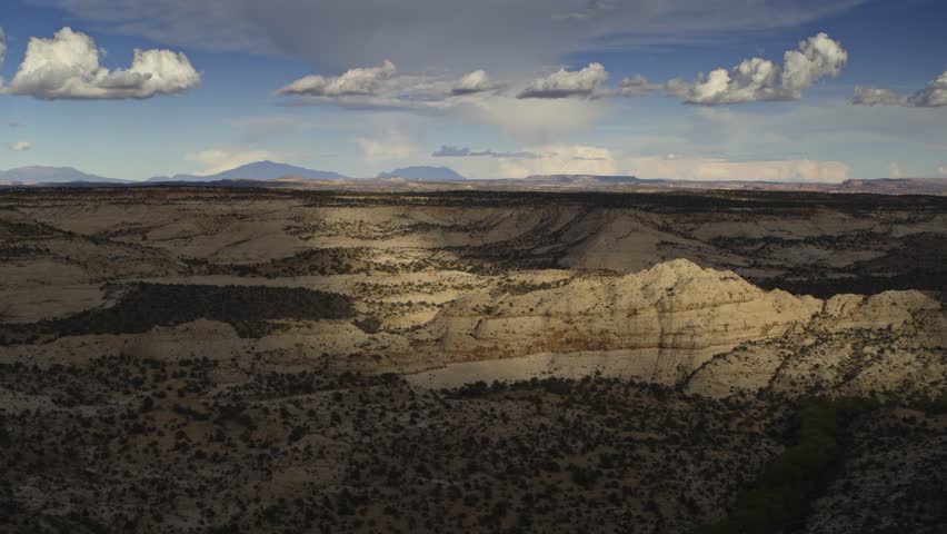 Aerial flyover view of clouds over sandstone rock formations, boulder, utah, united states