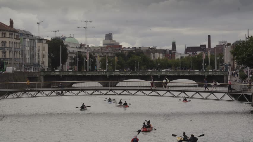 Slow motion of kayaks in river liffey under millennium bridge, dublin, ireland Royalty-Free Stock Footage #1099942137