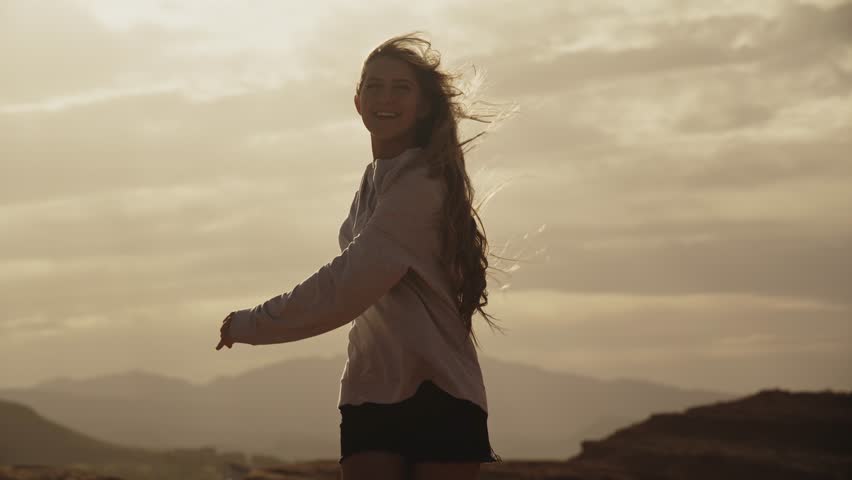 Portrait of smiling teenage girl spinning in desert at sunset, st. george, utah, united states