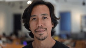 Asian 30s man portrait close up. Chinese guy look camera coworking background. Japanese person smile. Young korean male t-shirt. Adult thai people face. Nice freelancer. Serious brunette work China. - Powered by Shutterstock - Get 15% off with code: PIKWIZARD15