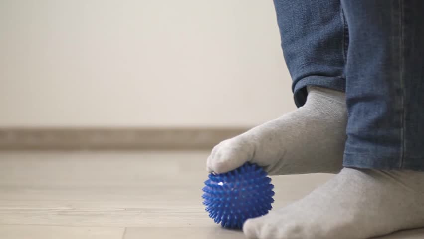 Uses a blue massage ball to knead the muscles of the foot. FullHD video in high quality. slow motion video