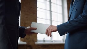 Business men exchange envelope concluding successful deal on office meeting closeup. Unknown manager in luxury suit giving financial payment premium for professional worker. Two partners shaking hands - Powered by Shutterstock - Get 15% off with code: PIKWIZARD15