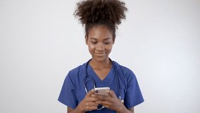 Doctor nurse black woman in blue uniform using smartphone to send text message. 5G Technology