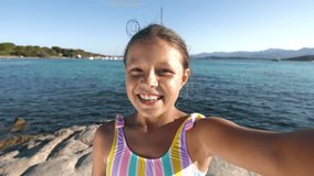 Point of View: Portrait of a Little Girl in a Swimming Suit Having a Video Call Using a Smartphone. Female Child Calling Friends During Summer Break from her Vacation on the Beach. Screen Replacement