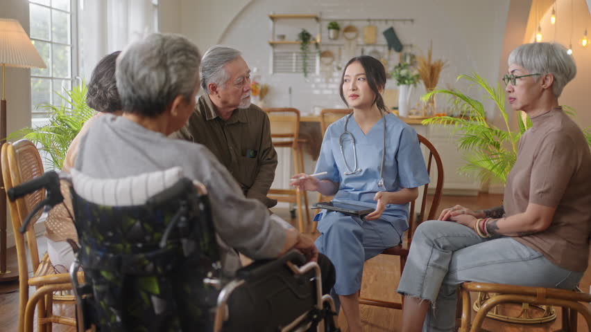 Group of asian senior people listening to young nurse.Psychological support group for elderly and lonely people in community centre. Group elderly therapy in session sitting in circle in nursing home Royalty-Free Stock Footage #1099949847