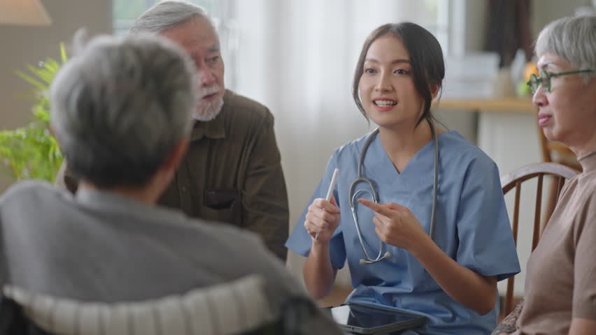 Group of asian senior people listening to young nurse.Psychological support group for elderly and lonely people in community centre. Group elderly therapy in session sitting in circle in nursing home Royalty-Free Stock Footage #1099949853