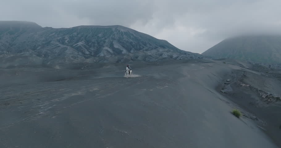 Panning Shot Of Person Riding Horse On Volcanic Landscape - Java, Indonesia