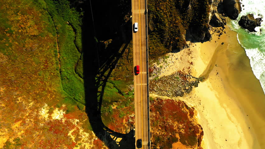 Aerial Top Shot Of Cars Moving On Road Of Bixby Creek Bridge, Drone Flying Upwards During Sunny Day - San Francisco, California