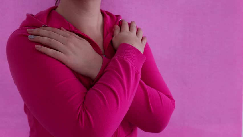 The girl hugs herself on a pink background. Concept for March 8th, #IWD2023, #EmbraceEquity, International Women's Day.	 | Shutterstock HD Video #1099954313