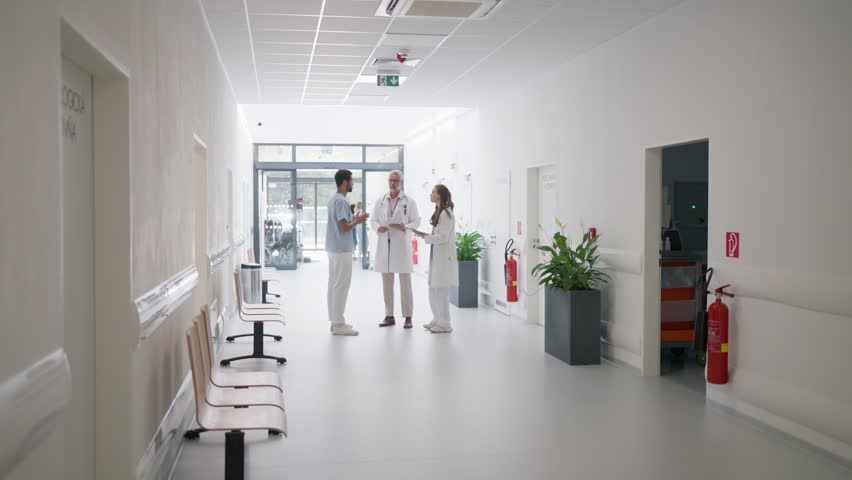 Team of doctors discusing at hospital corridor. | Shutterstock HD Video #1099957205