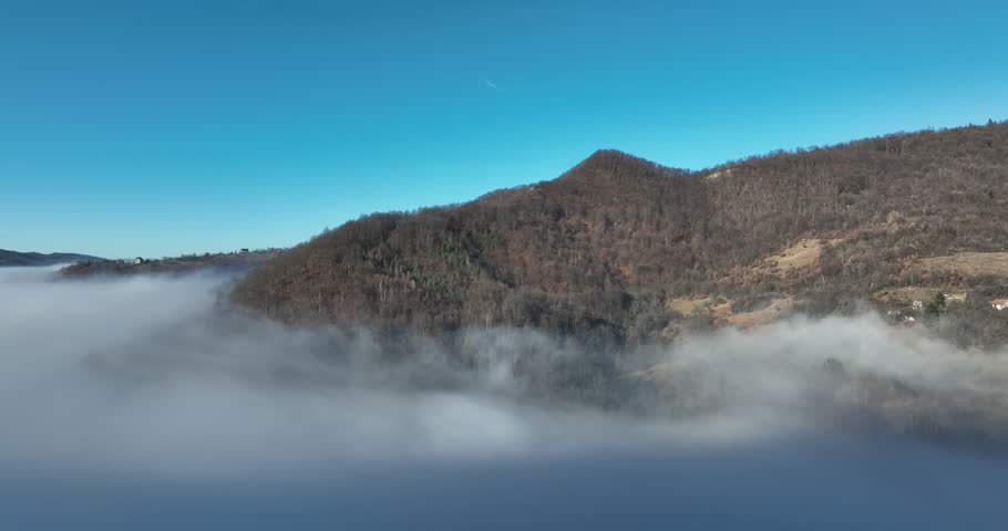 Aerial View. Flying over the high mountains in beautiful clouds. Aerial Drone camera shot. Air pollution clouds over Sarajevo in Bosnia and Herzegovina. 