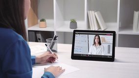 Business coaching. Video conference. Remote presentation. Confident female expert introducing statistics analysis to colleague using tablet taking notes at digital workplace.