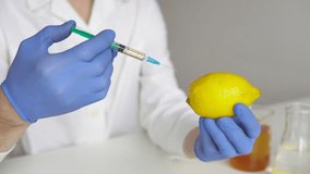 Scientist with syringe injects chemicals into lemon, Pesticides and fertilizers in fruits. - Powered by Shutterstock - Get 15% off with code: PIKWIZARD15