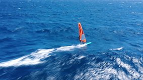 Aerial drone video of fit unidentified wind surfer racing in tropical exotic open ocean bay with deep blue wavy sea