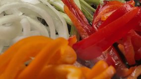 Super close-up of the fresh sliced red and yellow peppers falling on the pan to the onion and celery - Powered by Shutterstock - Get 15% off with code: PIKWIZARD15
