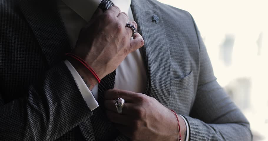 Handsome male hands fixing tie and jacket. the businessman defiantly adjusts his clothes. close-up of a man's hands in a tuxedo | Shutterstock HD Video #1099968403