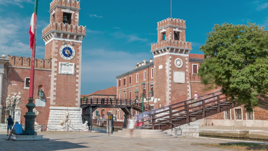 Entrance to the Arsenale timelapse, Venice, Veneto, Itlay. Campo de l'Arsenale with the canal and Ponte de l'Arsenal o del Paradiso on a sunny day with few tourists. Tower with clock Royalty-Free Stock Footage #1099968573