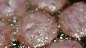macro video of sliced sausage in a frying pan.