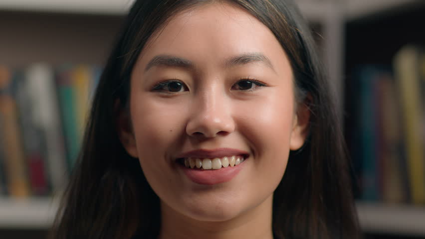 Close-up young happy confident korean businesswoman student teacher look camera in library joyful woman client customer smiling with teeth satisfied with service posing alone indoors female portrait | Shutterstock HD Video #1099973815
