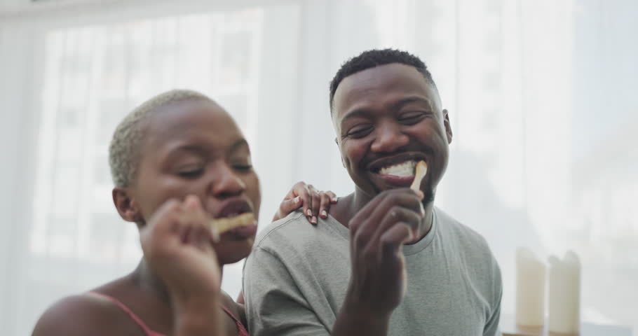 Brushing teeth, love and black couple with toothbrush in bathroom for morning routine, dental care and wellness. Smile, dating and man and woman with toothpaste for oral hygiene, health and cleaning | Shutterstock HD Video #1099979493