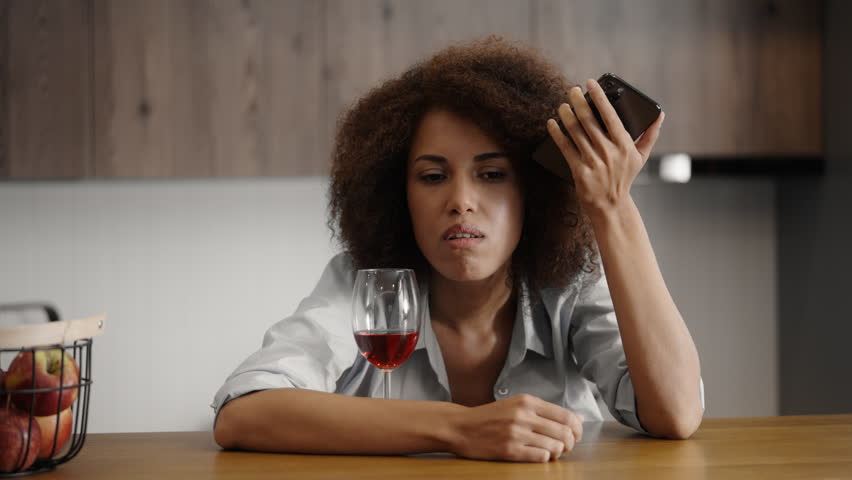 Young drunk woman calling her ex-boyfriend and drinking wine, harmful habit