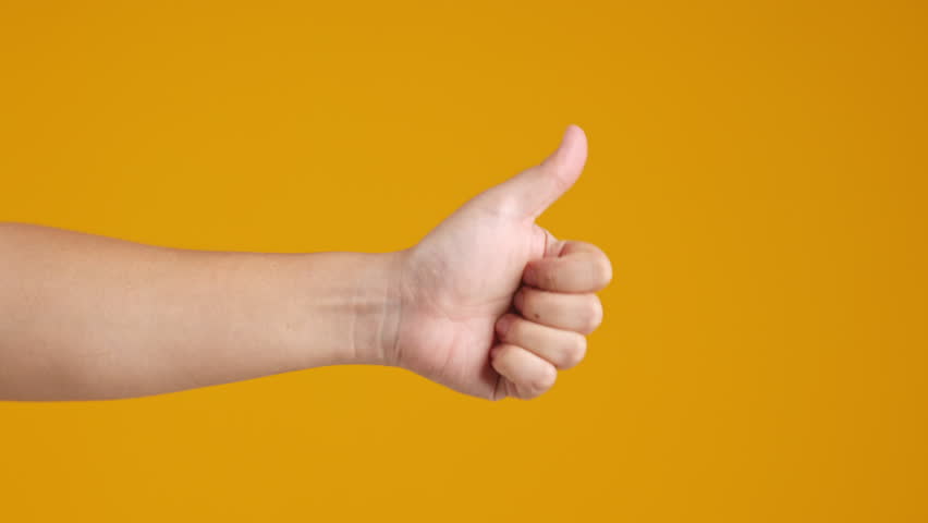 Hand giving thumbs up on yellow background