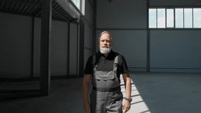 An adult gray-haired man worker walks through the warehouse, a working engineer walks through the territory of an empty logistics warehouse, cinematic lighting. - Powered by Shutterstock - Get 15% off with code: PIKWIZARD15