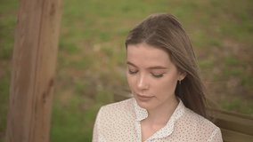 a girl in the park on a bench cries and wipes her tears with a handkerchief. slow motion video. High quality FullHD footage