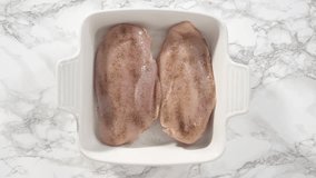 Time lapse. Flat lay. Step by step. Seasoning chicken with salt and pepper for baking in a baking dish.
