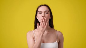 4k video of smiling woman on yellow background.