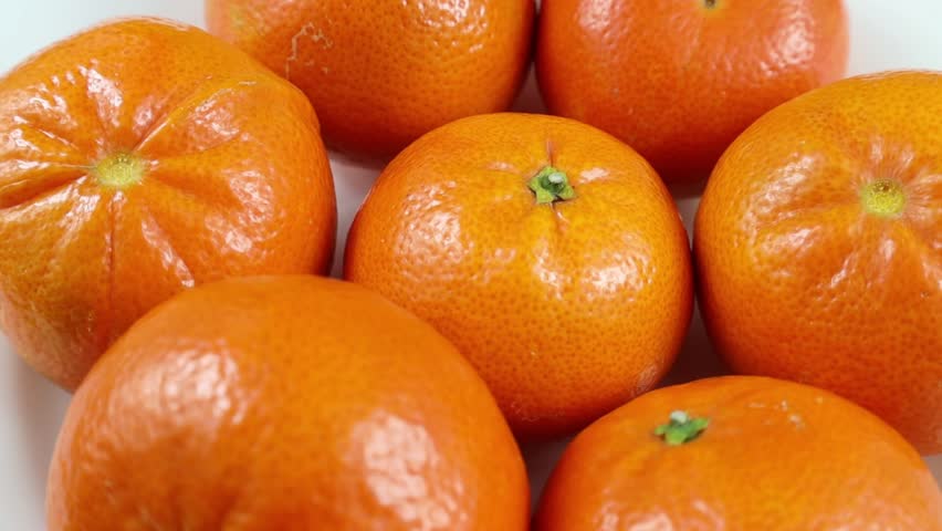 Many bright fresh orange mandarin fruit rotation close up