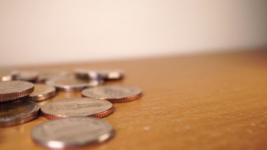 Closeup hand throwing a coin on the table