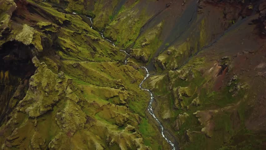 Aerial view over a river flowing and natural textures and patterns of the Icelandic terrain