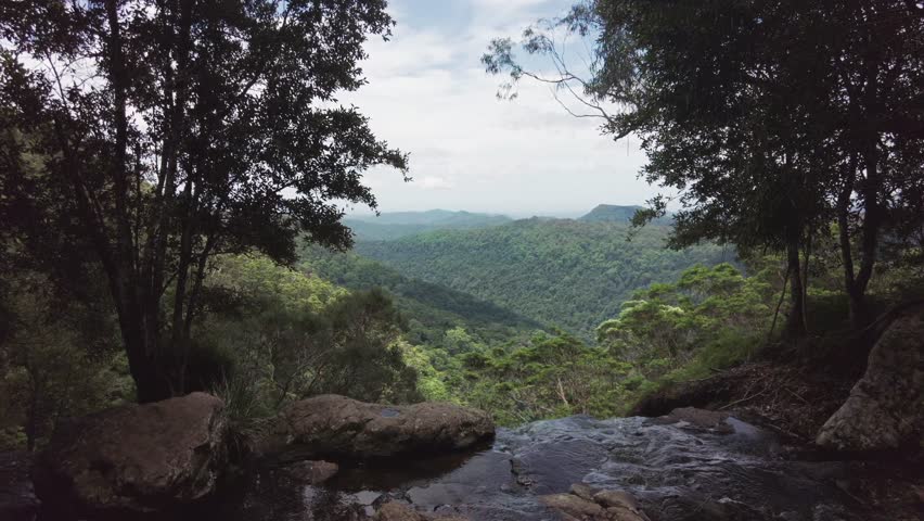 View Over Green Hills From Top of Waterfall