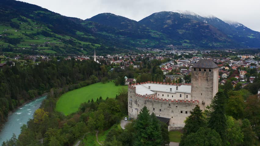 Aerial View Of Castle Bruck Beside River Isel In Austria With Town of Lienz In Background. Dolly Back