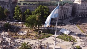 Drone flying around Argentinian flag waving in Plaza de Mayo during march LGBT event pride parade in Buenos Aires city. Aerial orbiting - Powered by Shutterstock - Get 15% off with code: PIKWIZARD15