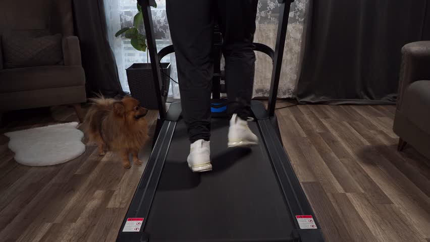 A man runs at home on a treadmill. Cardio Workout on the treadmill. Sport.