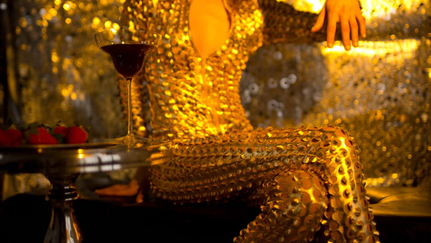 A beautiful woman wearing a gold masquerade mask and dancing