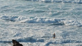Sea waves crashing coastline cliff in summer. White foaming ocean rolling beach on stormy day slow motion. Unknown woman silhouette relax enjoy massive water stream on vacation. Powerful wild nature - Powered by Shutterstock - Get 15% off with code: PIKWIZARD15