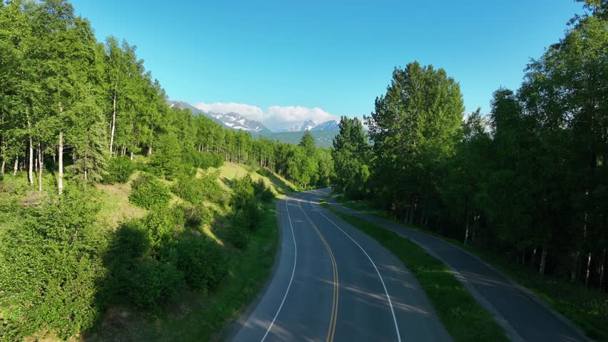 Sunshine Over The Dense Forest By The Highway In Anchorage, Alaska. Aerial Drone Shot