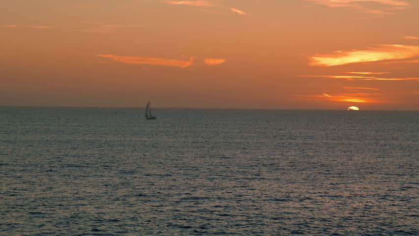 Beautiful golden sea sunrise in summer. Lonely boat sailing calm ocean sunset. Picturesque seaside landscape with bird flying over peaceful morning water. Idyllic travel fantasy paradise concept.
