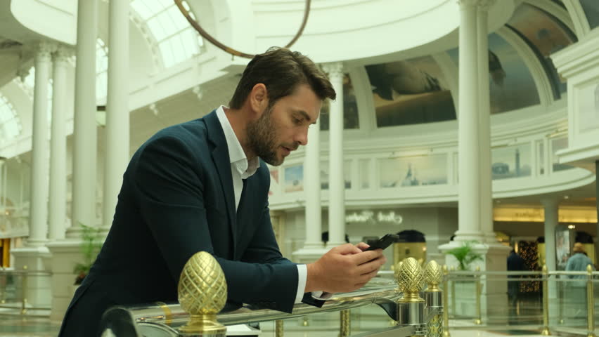 Male millennial professional holding modern smartphone texting message. Young businessman using helpful mobile apps for business time management organization concept.