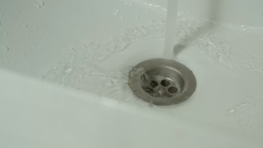 Leaking water in bathroom, problem of water shortage in the world. Concept of saving water and don't leave the crane open while you washing hands or face | Shutterstock HD Video #1100035939