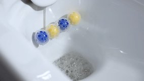 Close-up of an antiseptic against fungus remedy. Flush the toilet with foamy soapy water. Scented balls for the toilet. Bath scented antimicrobial balls