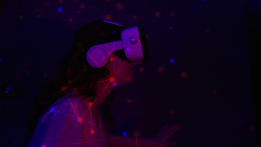 Woman Using Virtual Reality Headset Looking Around At Interactive Art Performance Colorful Illumination. Girl Sitting in Dark Room With Neon Light Playing Games With VR Headset Virtual simulation Royalty-Free Stock Footage #1100038841