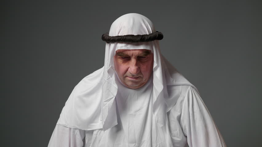 Elderly man with united arab emirates traditional clothes posing in a studio. Beautiful islamic portrait of portrait arab businessman kandur. Studio footage with different poses