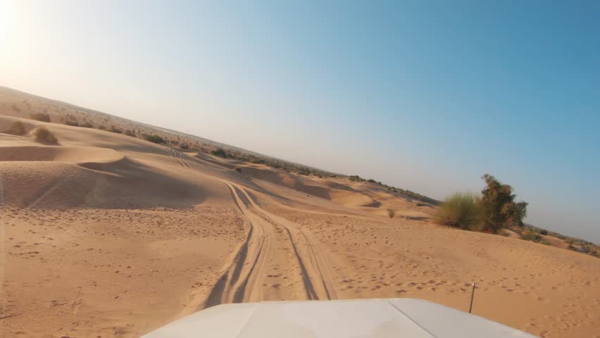 4K POV of a vehicle dune bashing on the sand dunes of the Thar desert at Jaisalmer in Rajasthan, India. Car moves on the desert during the day. Extreme adventure in the desert background. Royalty-Free Stock Footage #1100044847