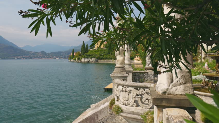Gimbal shot of famous luxury villa Monastero and botanical garden decorated with mediterranean oleander flowers. Ornamental green park with villa Monastero, lake Como, Varenna, Lombardy region, Italy
