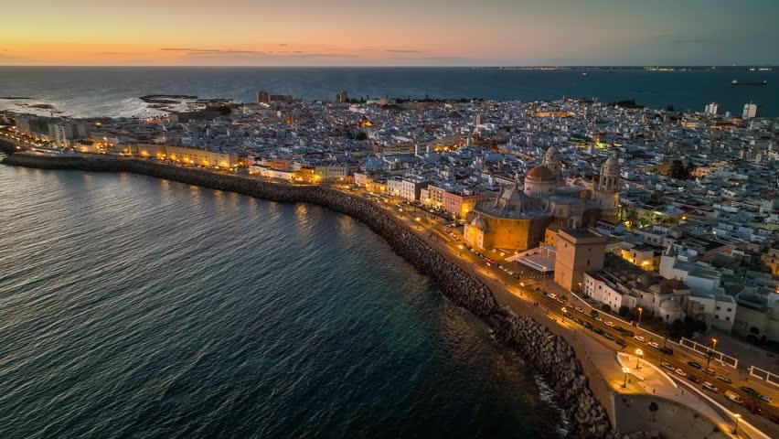 Sunset view of Cadiz with city lights, Andalusia, Spain . Great aerial view of evening Cadiz and Catedral de Santa Cruz de Cadiz. UHD HDR shot Royalty-Free Stock Footage #1100045795